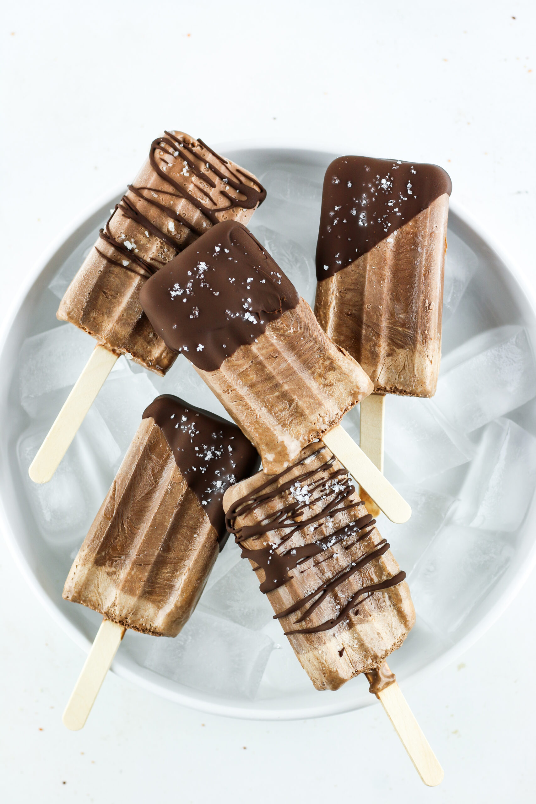 Chocolate drizzled fudgesicles made with cottage cheese.