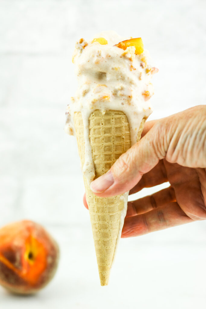 Peach cottage cheese ice cream on a waffle cone.