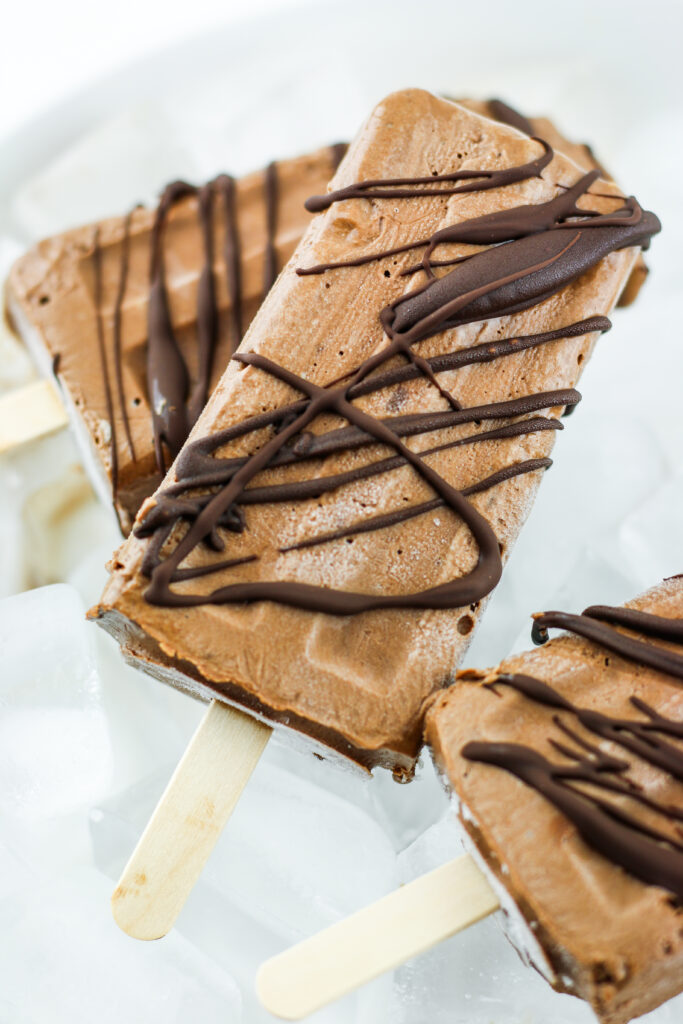 Chocolate drizzled fudgesicles made with cottage cheese.