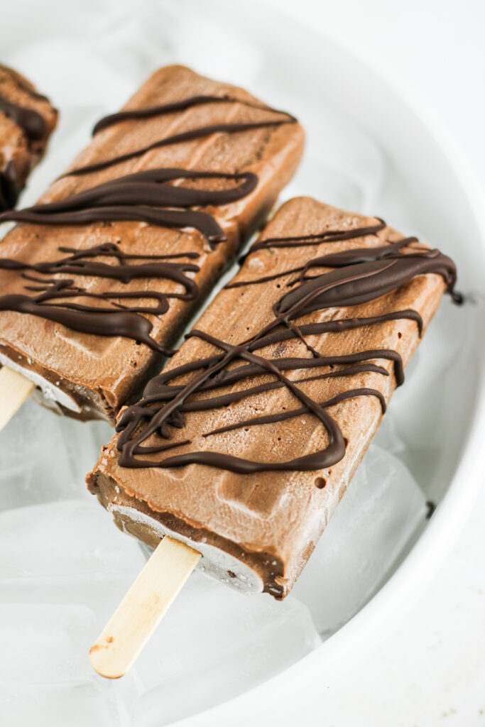 Chocolate drizzled fudgesicles made with cottage cheese.