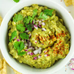 A bowl of cottage cheese guacamole with chips to enjoy this high protein dip.