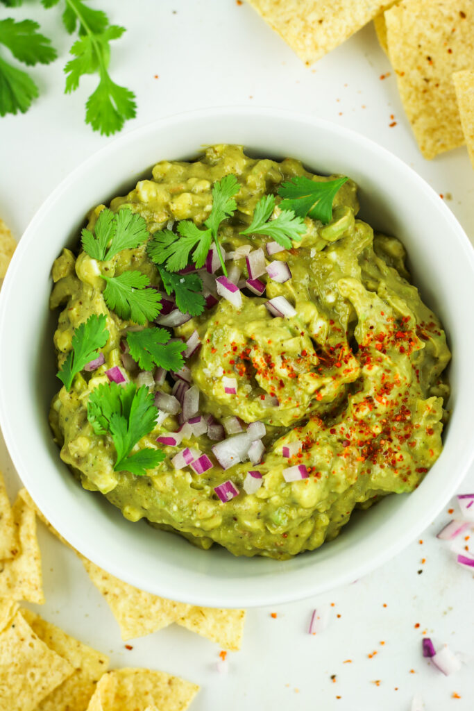 A bowl of cottage cheese guacamole with chips to enjoy this high protein dip.