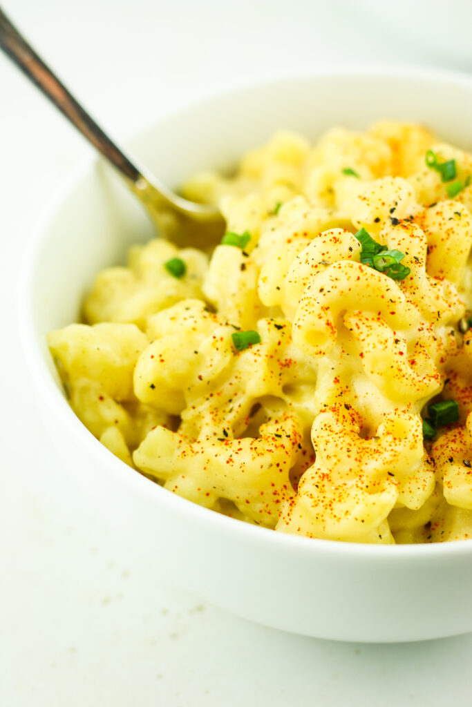 A warm bowl of Cottage Cheese Mac and Cheese topped with fresh chives.