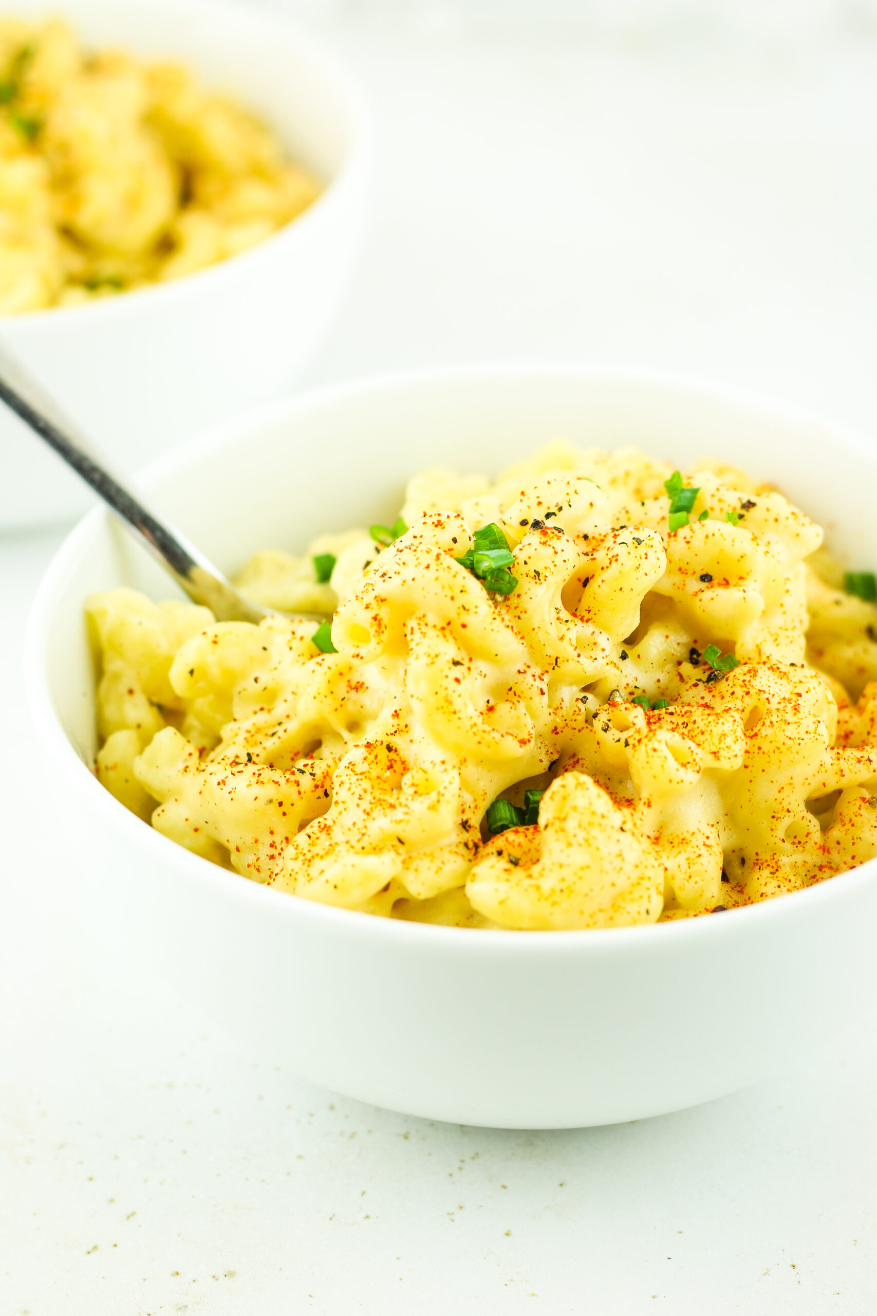 A warm bowl of Cottage Cheese Mac and Cheese topped with fresh chives.